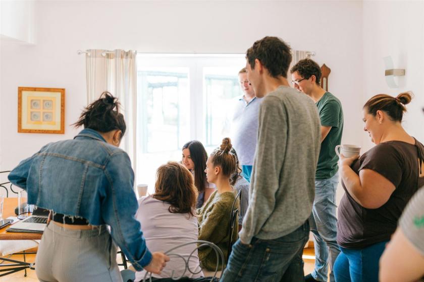 Fünf Personen, Die In Der Nähe Von Vier Personen Stehen, Die In Der Nähe Des Schreibtisches Sitzen